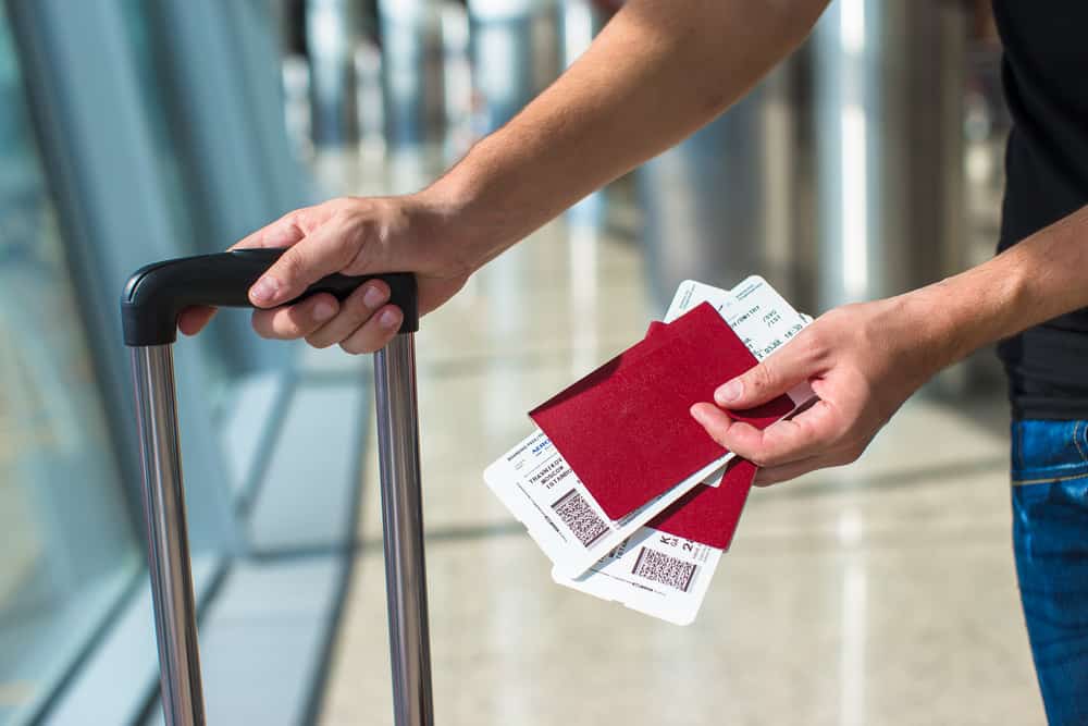 A man holding passports and boarding passport at airport.