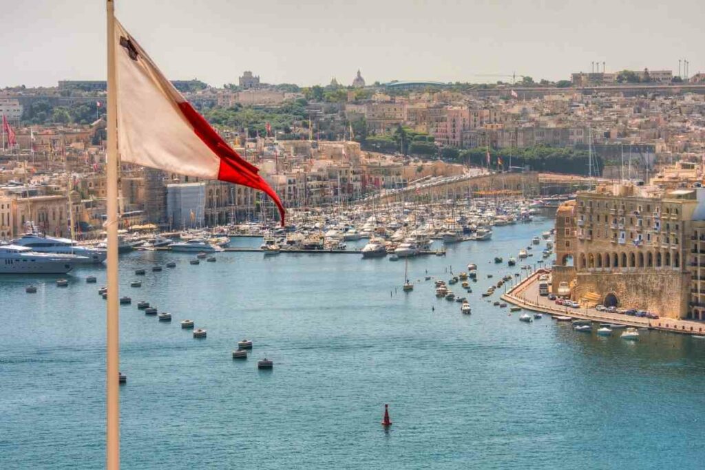 Sea port in Malta with the flag of malta in the front view