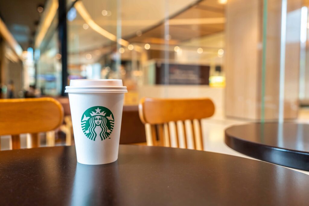 Starbucks hot beverage coffee with holder on the table in Starbuck coffee shop at airport.